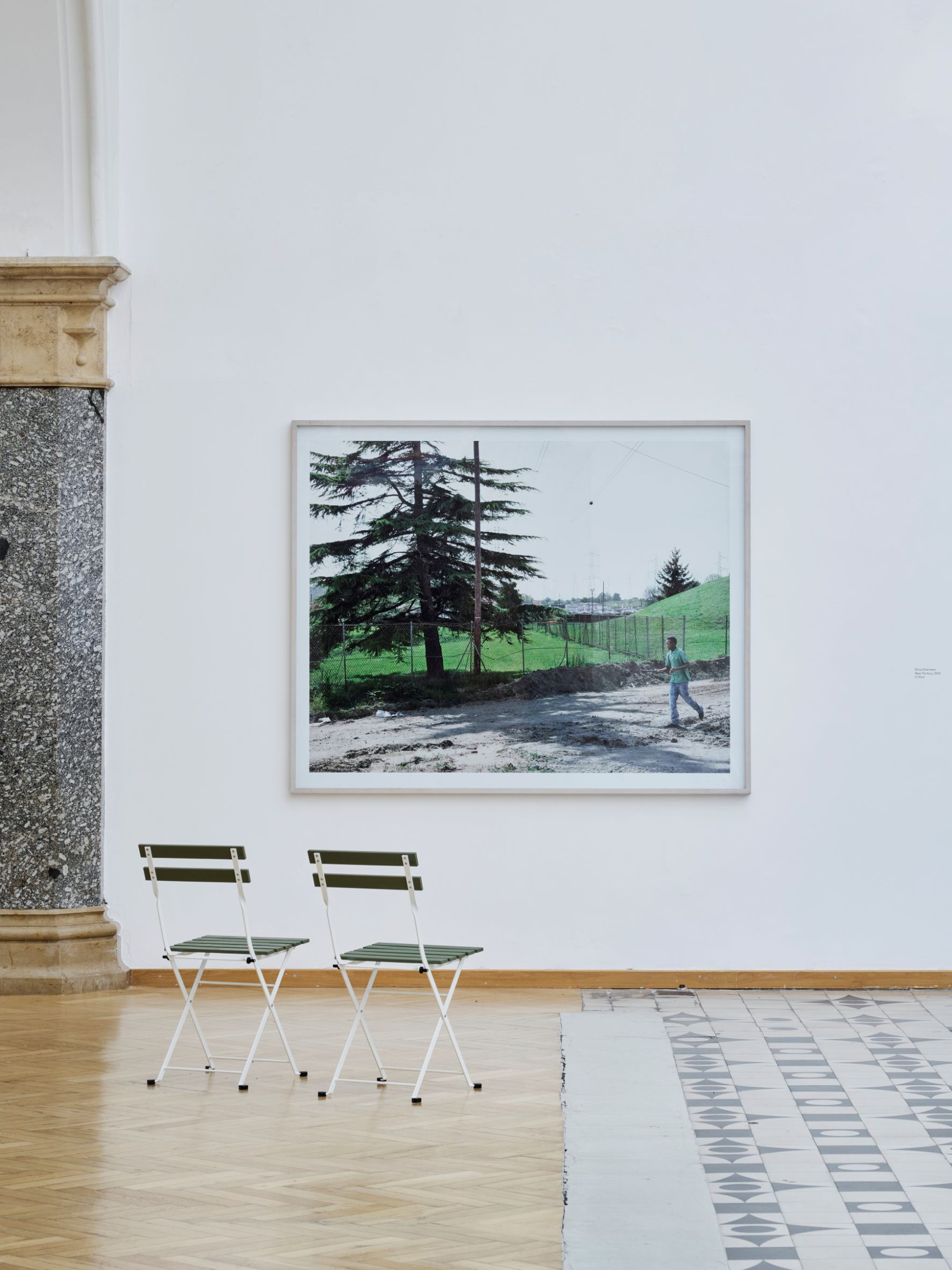 grosser-fotoprint-von-erica-overmeer-farbig-an-der-wand-zeigt-landschaft-mit-junge-teil-der-ausstellung-onside-offside-rathausgalerie